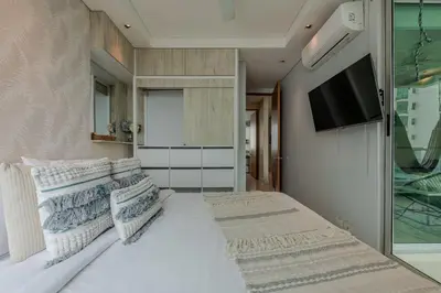 a bedroom with a bed with pillows and a tv at Apartamento con vista al mar - Piscina en la azotea - 2 habitaciones + 2 baños in Cartagena de Indias