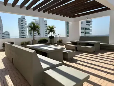 a rooftop patio with tables and benches on a building at Apartamento con vista al mar - Piscina en la azotea - 2 habitaciones + 2 baños in Cartagena de Indias