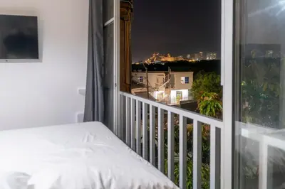 a bedroom with a balcony with a view of a city at Cartagena Apartamento in Cartagena de Indias