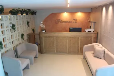 a waiting room with two chairs and a reception desk at Hotel Fontamar 72 in Barranquilla