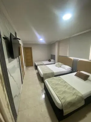 a hotel room with three beds and a flat screen tv at Hotel Fontamar 72 in Barranquilla