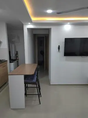 a kitchen with a table and a tv on a wall at Espectacular apartamento amoblado en BARRANQUILLA in Barranquilla