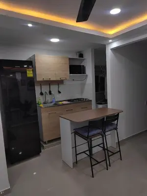 a kitchen with a table and two chairs and a refrigerator at Espectacular apartamento amoblado en BARRANQUILLA in Barranquilla