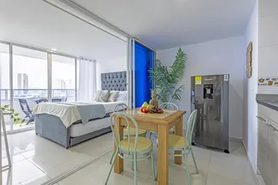 a bedroom with a bed and a table and chairs at Riviera Coral Beach - Con vista al mar in Cartagena de Indias