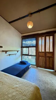 a bedroom with a bed and a large window at Casa del Tunel Lodge in Getsemani in Cartagena de Indias