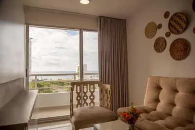 a living room with a chair and a large window at Cartagena Económica con Estilo y Comodidad in Cartagena de Indias