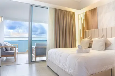 a bedroom with a bed and a view of the ocean at Ocean View ApartaSuite 16th Floor in Cartagena de Indias