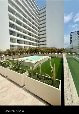 a large building with a swimming pool and plants at Ocean View ApartaSuite 16th Floor in Cartagena de Indias