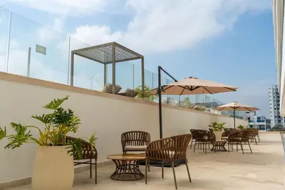 a patio with chairs and tables and umbrellas at Ocean View ApartaSuite 16th Floor in Cartagena de Indias
