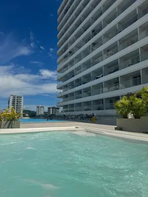 a swimming pool in front of a large building at Moderno Apto cerca del Mar y Aeropuerto in Cartagena de Indias