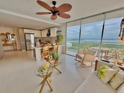 a living room with a ceiling fan and a kitchen at Sea view with private balcony in Cartagena de Indias