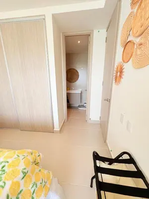 a bedroom with a bed and a chair and a hallway at Sea view with private balcony in Cartagena de Indias