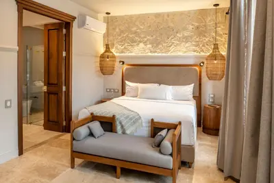 a bedroom with a bed and a chair in it at Hotel Casa Sonara in Cartagena de Indias