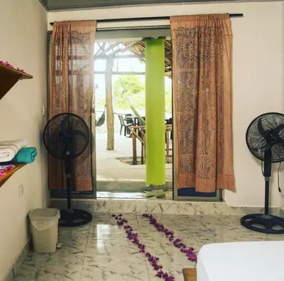 a room with two fans on the floor next to a window at eco hotel lili in Isla Fuerte