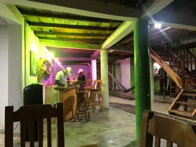 a group of people sitting at a bar in a building at eco hotel lili in Isla Fuerte