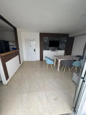 a living room with a table and blue chairs at Apartment near the beach and airport in Cartagena de Indias