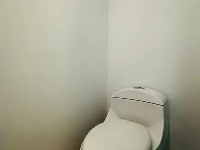a white toilet in a corner of a bathroom at Amazing loft - 2 minutes from the airport! in Cartagena de Indias