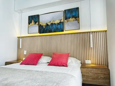 a bedroom with a bed with two red pillows at Amazing loft - 2 minutes from the airport! in Cartagena de Indias