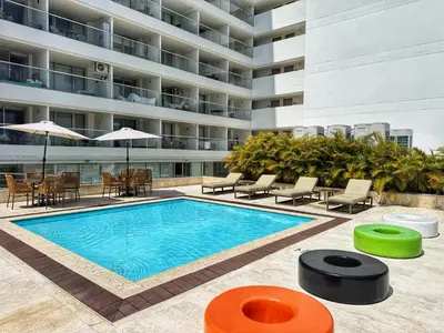 a swimming pool in front of a building at Amazing loft - 2 minutes from the airport! in Cartagena de Indias