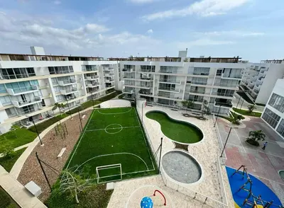 an apartment complex with a tennis court in front of it at Hermoso apartamento serena del mar #1 in Puerto Tierrabaja