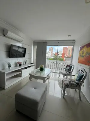 a living room with a table and chairs and a tv at Apartamento diagonal a bv norte in Barranquilla