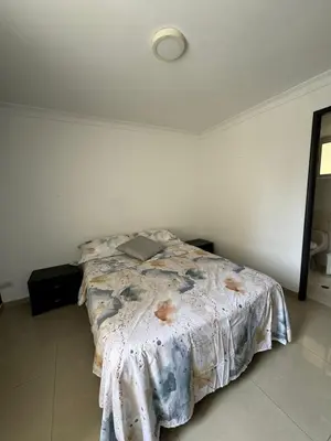a bedroom with a bed in a white room at Apartamento diagonal a bv norte in Barranquilla