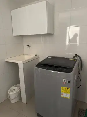 a small kitchen with a trash can and a white cabinet at Apartamento diagonal a bv norte in Barranquilla