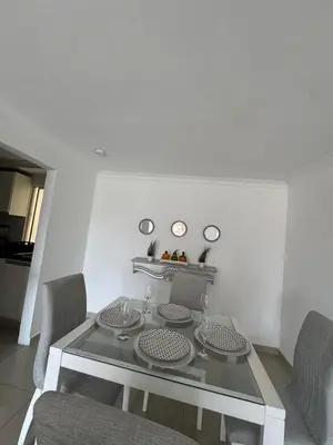 a dining room with a glass table and chairs at Apartamento diagonal a bv norte in Barranquilla