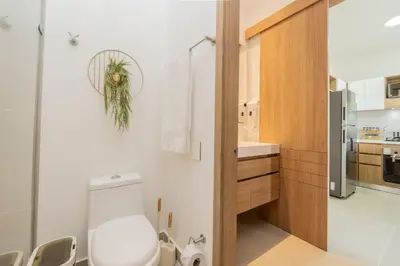 a bathroom with a white toilet and a kitchen at BK2L | Escápate a Baía Kristal, sol + arena blanca in Los Arrayanes