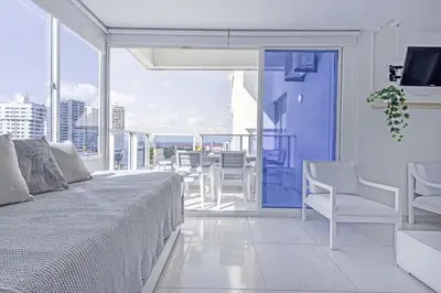a bedroom with a bed and a balcony with a table and chairs at Riviera Exclusive - Apartamento con vista al mar in Cartagena de Indias