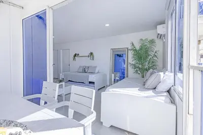 a white room with two beds and a table and chairs at Riviera Exclusive - Apartamento con vista al mar in Cartagena de Indias