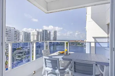 a balcony with a table and chairs and a view of the ocean at Riviera Exclusive - Apartamento con vista al mar in Cartagena de Indias