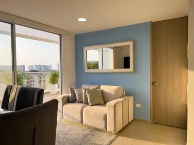 a living room with a couch and a mirror at 2 cuartos terraza piscina AC in Cartagena de Indias