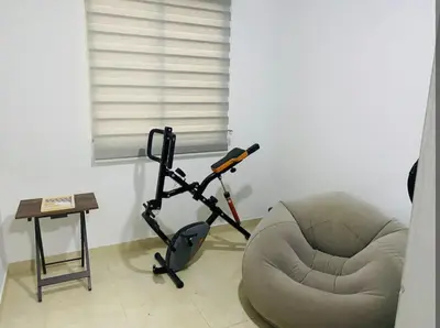 a living room with a chair and a exercise bike at Apartamento en Barranquilla in Barranquilla