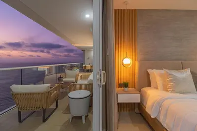 a bedroom with a bed and a balcony with a view at Luxury Ocean View Apartment Building H2 - Hyatt in Cartagena de Indias