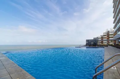 a large swimming pool with a view of the ocean at Luxury Ocean View Apartment Building H2 - Hyatt in Cartagena de Indias