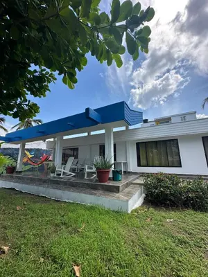 a white house with a blue roof at Casa Blanca in Coveñas