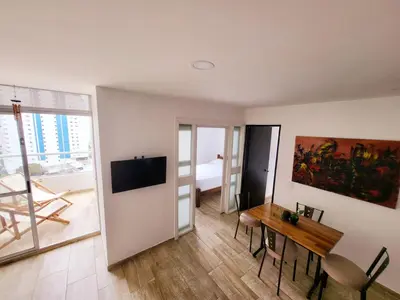a living room with a dining room table and a television at Departamento con vista al mar in Cartagena de Indias