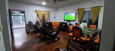 a living room with chairs and a table and a tv at Cabañas villa Ángela in Coveñas