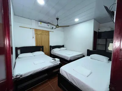 two beds in a small room with white sheets at Cabañas villa Ángela in Coveñas