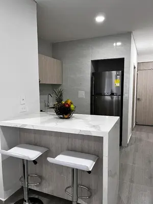 a kitchen with a counter with two stools and a refrigerator at Apt luxury wifi AC pool at Cartagena in Cartagena de Indias