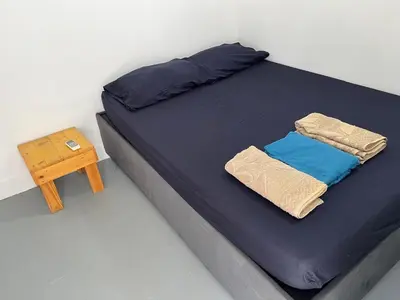 a bed with blue sheets and a wooden table at Habitación cerca a la playa 205 in Cartagena de Indias
