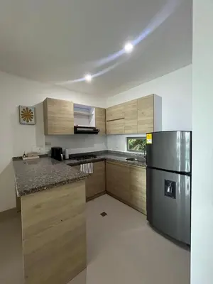 a kitchen with wooden cabinets and a stainless steel refrigerator at Apto Caribe Mar in Coveñas