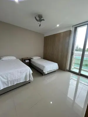 a bedroom with two beds and a large window at Apto Caribe Mar in Coveñas