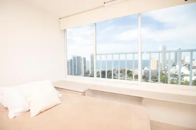 a bedroom with a large window with a view of the city at Riviera Beach - Apartamento con vista al mar in Cartagena de Indias
