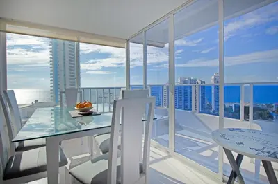 a dining room with a table and chairs on a balcony at Riviera Beach - Apartamento con vista al mar in Cartagena de Indias