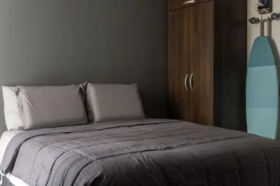 a bedroom with a bed and a wooden cabinet at Apt luxury near sea wifi Ac pool at Cartagena in Cartagena de Indias