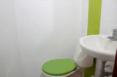 a bathroom with a green toilet and a sink at Hotel Catedral inn B SAS in Barranquilla
