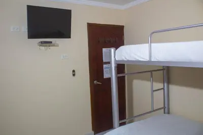 a room with two bunk beds and a flat screen tv at Hotel Catedral inn B SAS in Barranquilla