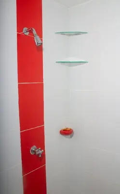 a shower with a red and white wall at Hotel Catedral inn B SAS in Barranquilla